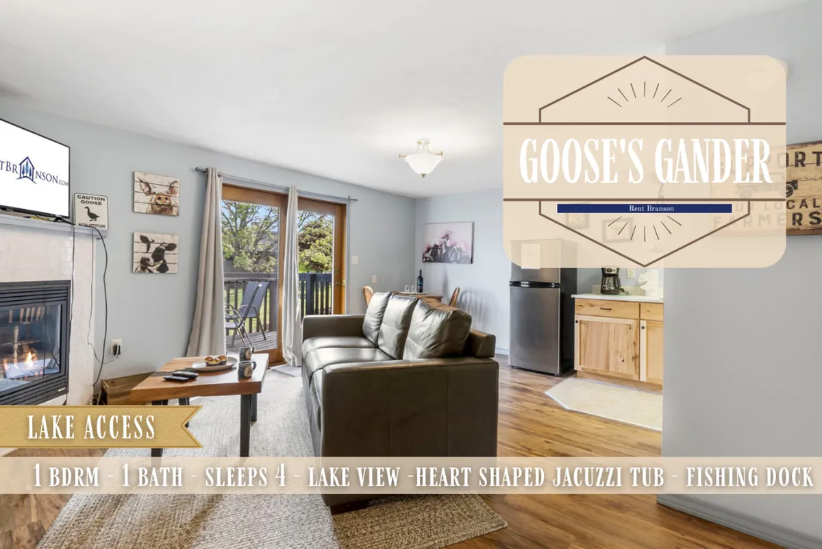 A spacious and inviting interior with a fireplace, sofa, and large windows framing a lake view. The room includes a dining area, suggesting versatility for both relaxation and socializing.
