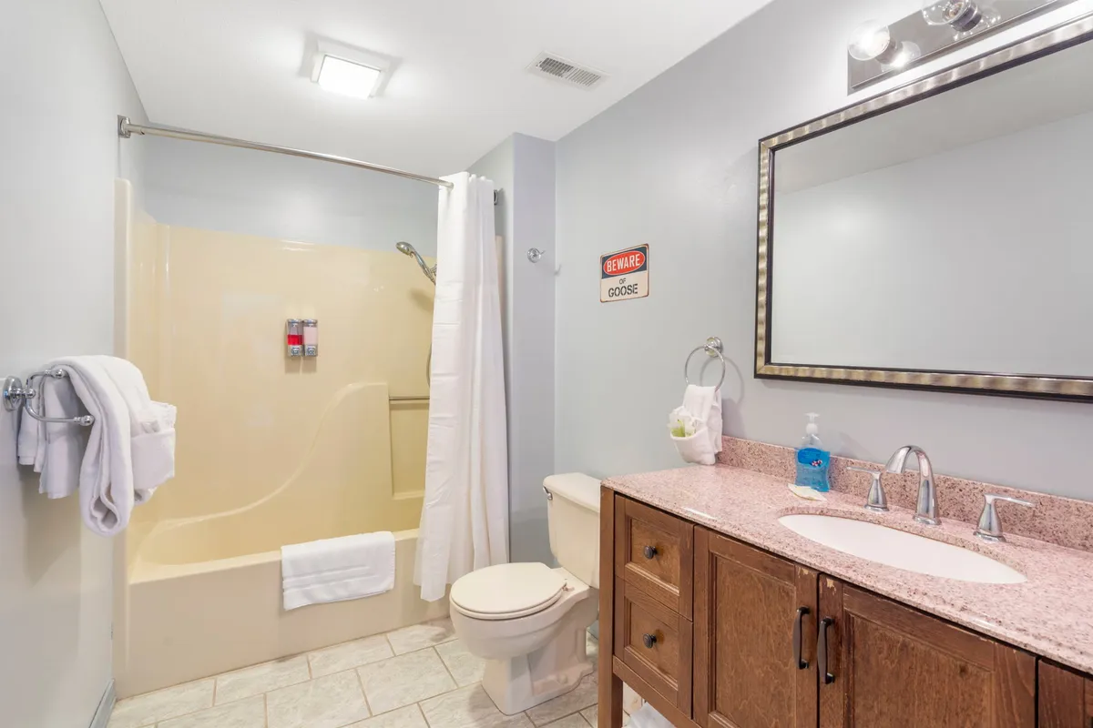 A well-appointed private bathroom with a modern vanity and sink, a glass-enclosed shower area, and a large mirror. The layout is inviting yet functional, supporting both rejuvenation and daily routines.
